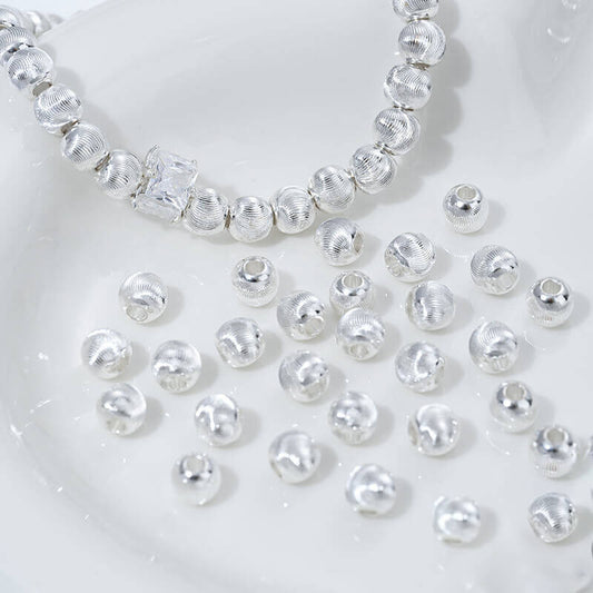 Fine patterned cat's eye faceted round beads with brushed spacer beads
